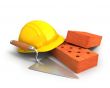 Bricks, trowel and a yellow plastic helmet 