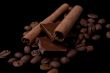 Cinnamon sticks over coffee beans and chocolate