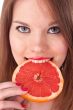girl and grapefruit in her teeth