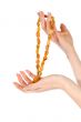 Woman hands holding amber necklace