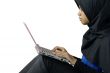 Serious muslim asian lady using laptop