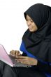 Happy asian muslim lady using laptop