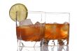 glass of whiskey with ice cubes on white