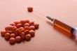 Red Tablet and syringe on red closeup