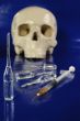 Medical syringe, ampoules and skull 