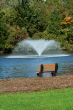 Fountain on a pond with park bench