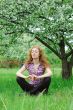 Woman meditating under blooming tree