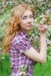 Red-haired woman among apple blossom