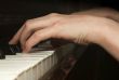 Child`s hand playing on piano keyboard