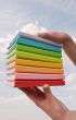Hands holding color hard cover books