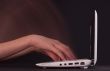 Hands typing in motion on the laptop keyboard