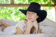 beautiful girl in the hat lying in the open air