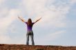 Young woman staying with raised hands