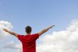 Young man staying with raised hands 