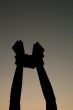 Hands tied up with rope against dark sky