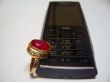 Mobile phone and golden ring with red stone