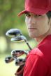 Golfer holding golf clubs.