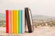 Row of colorful books with e-book reader