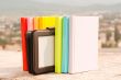 Row of colorful books with e-book reader