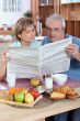 Couple reading the newspaper over breakfast