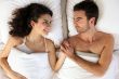 Young couple holding hands in bed