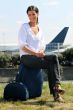 young businesswoman seated on luggage