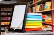 Stack of colorful books with e-book reader