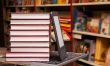 Stack of colorful books with e-book reader