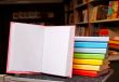 Open book with a stack of colorful books