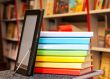 Stack of colorful books with e-book reader