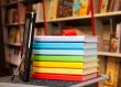 Stack of colorful books with e-book reader