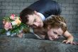 Bride and groom near a wall