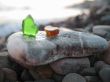 Green and orange glass laying on the sea shore