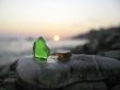 Green and orange glass laying on the sea shore