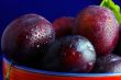 Plums. Fresh ripe washed plums in a ceramic bowl close-up on a b