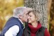Middle-aged couple kissing by tree