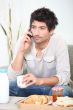 Man making a phone call over breakfast