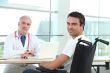 Young man in a wheelchair talking to a doctor