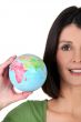 young woman taking a little globe in her hand