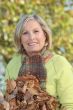 Woman with an armful of autumnal leaves
