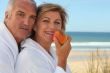 Mature couple in bathrobes on the beach