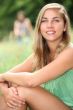 Young woman sitting in a meadow in the summertime