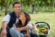 couple picking grapes and drinking wine