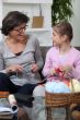 Grandmother knitting with her granddaughter