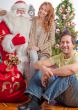 Happy family embracing and sitting on the floor in front of Christmas tree