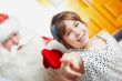 Christmas theme: Santa Claus and little girl having a fun. 