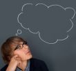 Image of young man thinking of his plans. Lots of copyspace inside graphic cloud for your text.