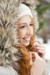 Portrait of pretty girl at winter background wearing warm clothes.