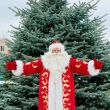 Portrait of Santa Claus standing with open hands outdoors at chr