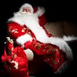 Santa sitting with a sack indoor at dark night room